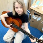 Uczeń gra na gitarze w ramach muzykoterapii